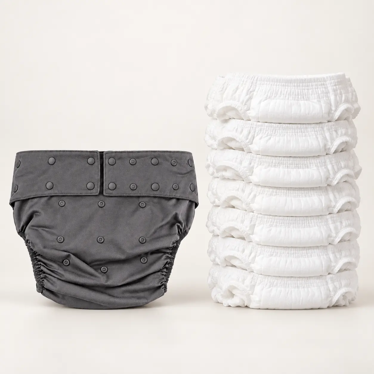 One washable adult diaper shown against a pile of single-use incontinence products